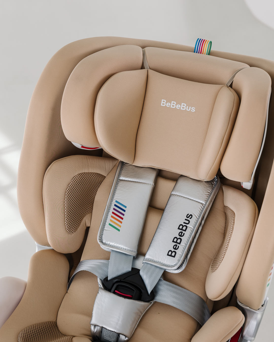 BeBeBus Astron+ PRO Car Seat showing soft padded infant headrest and silver five-point safety harness.
