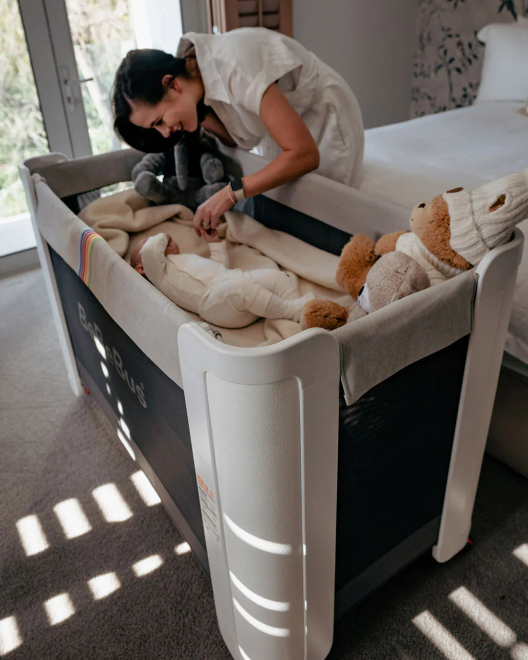 Mother bonding with baby inside the BeBeBus Wish Crib, showing its roomy interior and function as a safe, cozy playpen.
