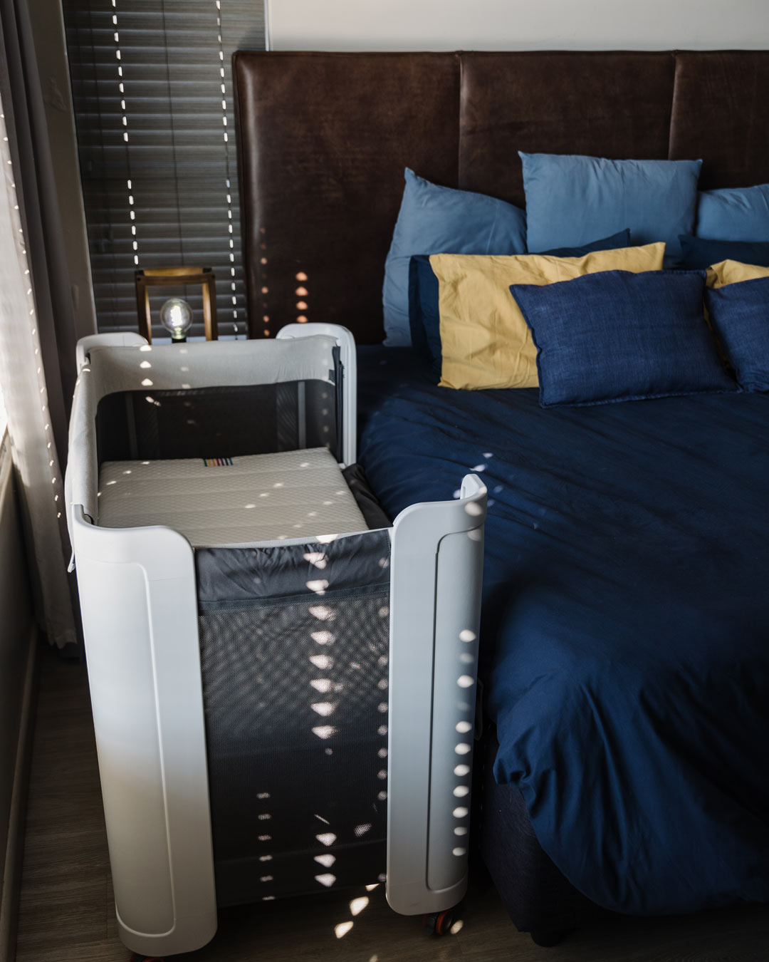 BeBeBus Wish Crib used as a co-sleeper next to adult bed, perfect for nighttime bonding and safe, accessible sleep for newborns.