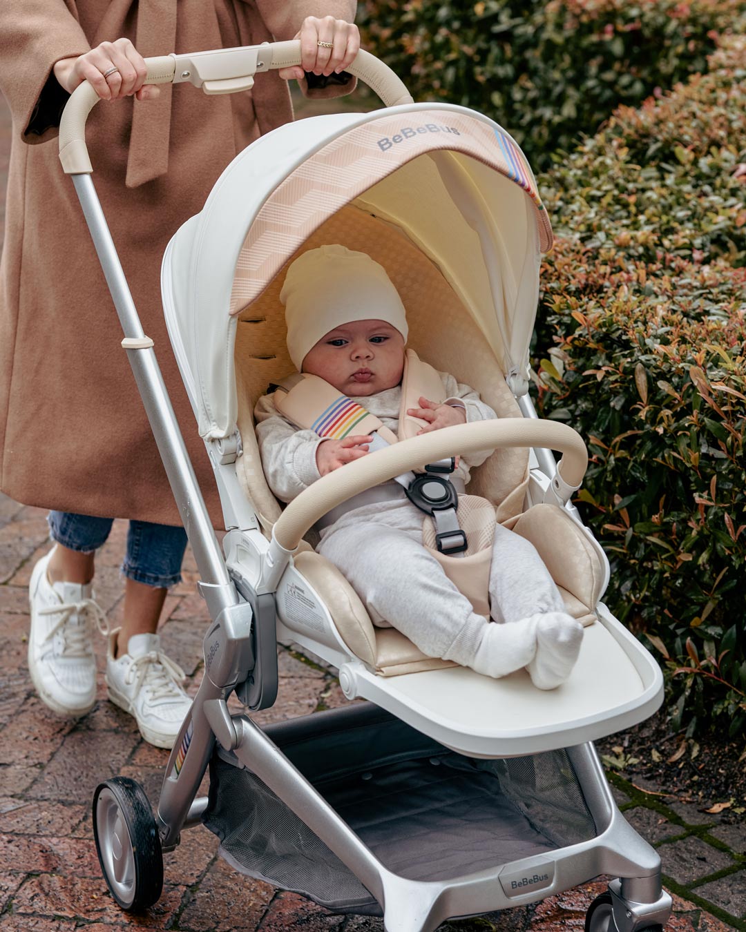 Baby snug in BeBeBus Art+ PRO Stroller during a walk, showcasing secure 5-point harness and padded comfort for infant safety on the go.