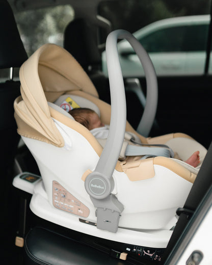 Newborn safely secured in the BeBeBus Guard baby car seat, rear-facing inside a vehicle with ISOFIX base installed.