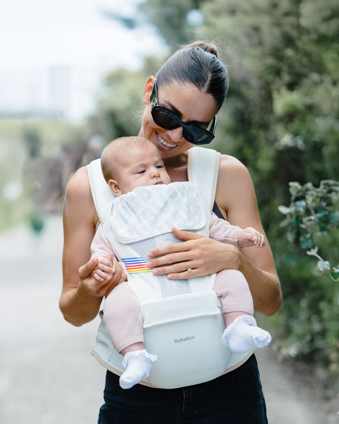 Mother holding her baby in a BeBeBus Baby carrier in outward facing mode.
