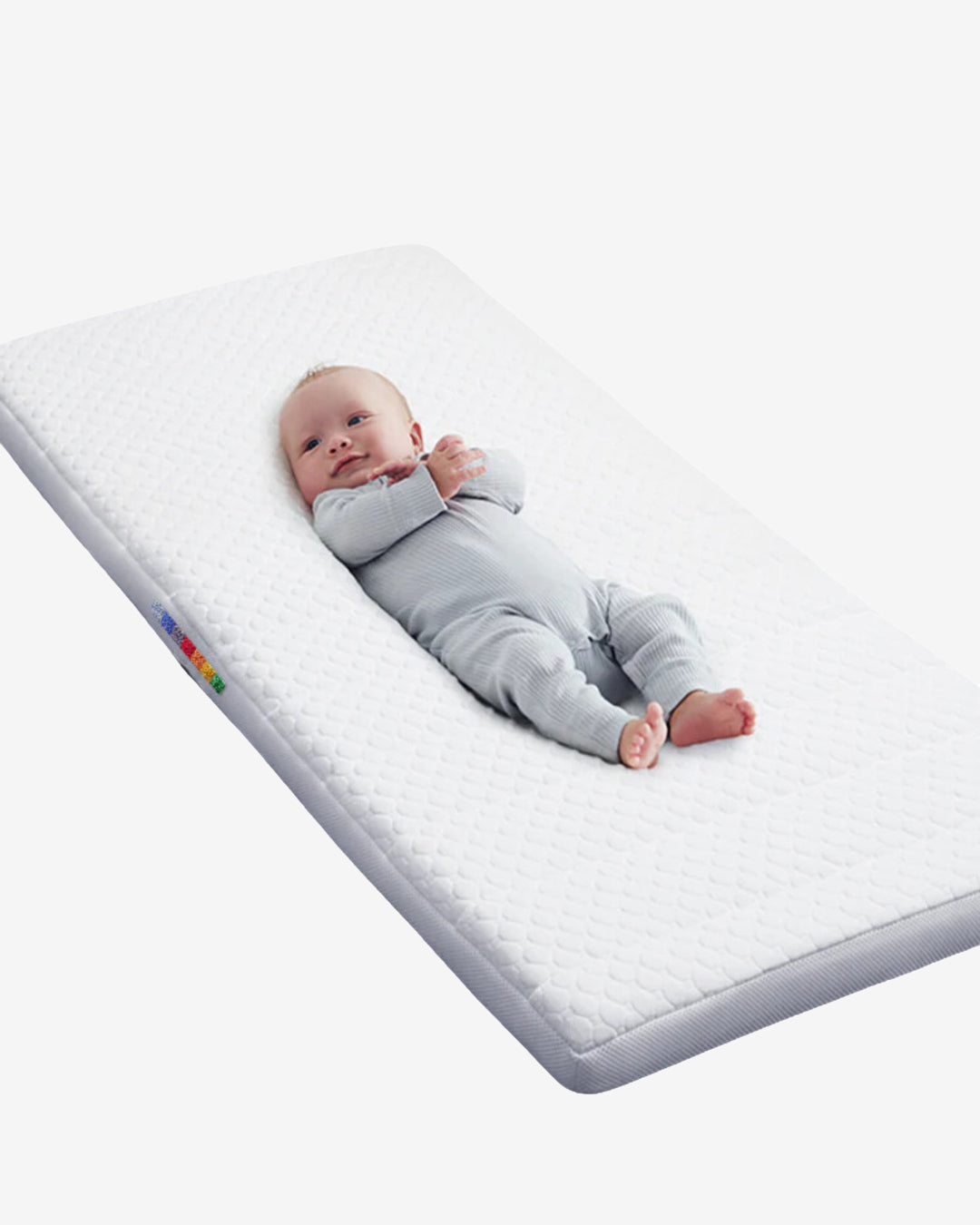 Baby lying comfortably on the BeBeBus infant mattress with quilted support and soft breathable cover.
