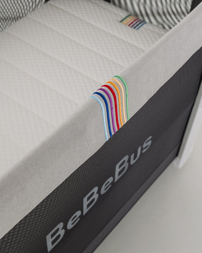 Close-up of BeBeBus crib and mattress with colourful stitching, highlighting breathable side mesh and modern design.