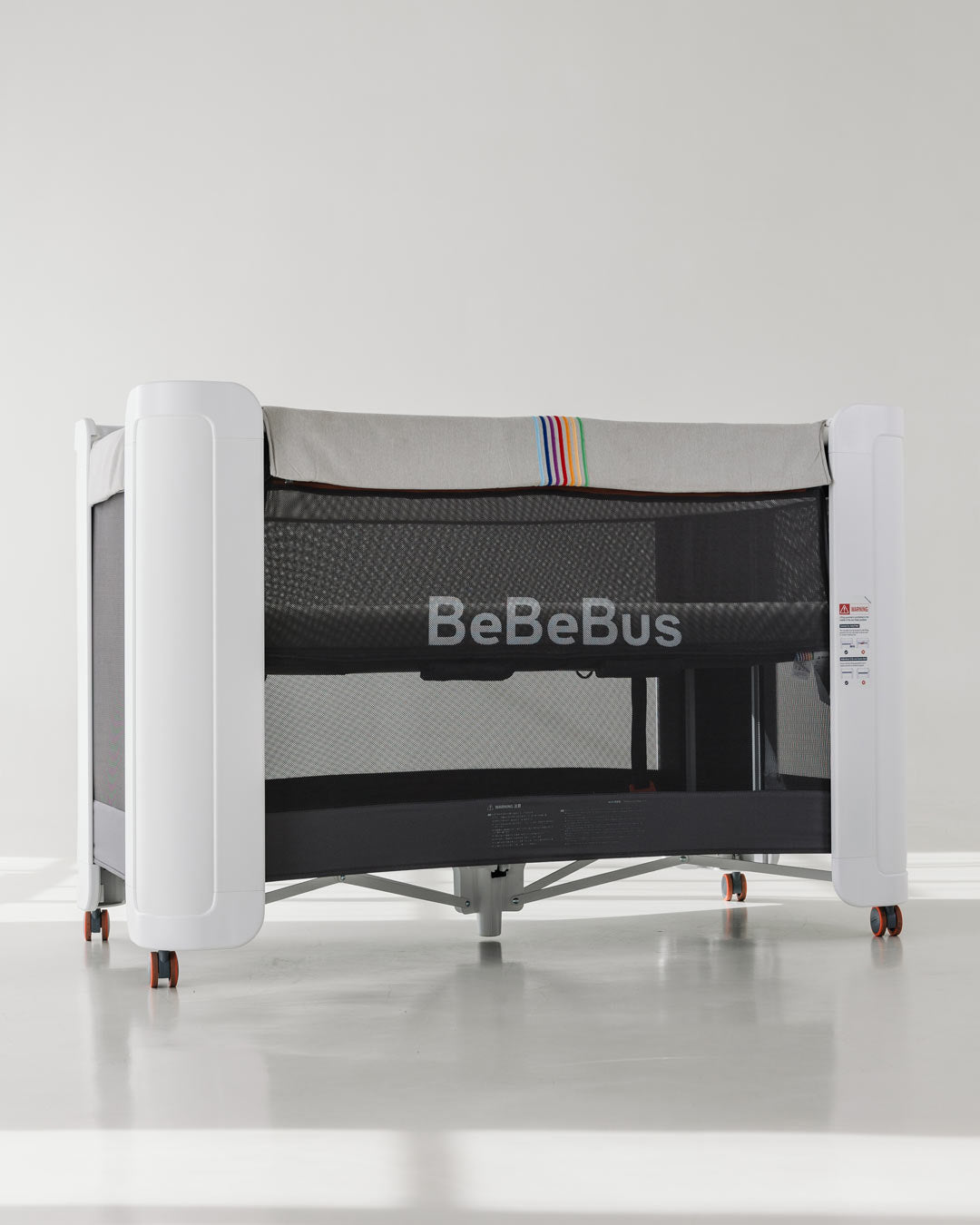BeBeBus Wish Crib with breathable mesh sides and modern design, serving as a crib, co-sleeper, and playpen in one versatile solution.