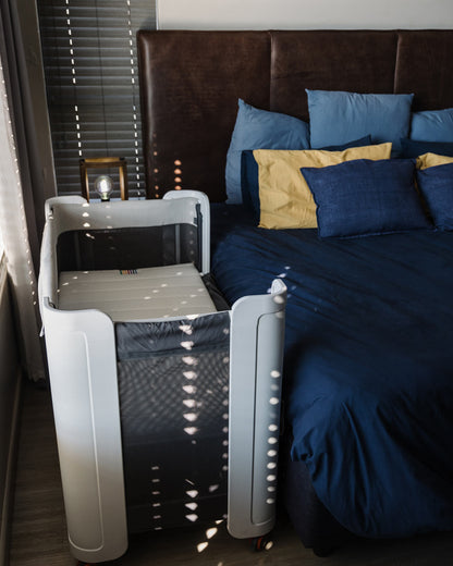 BeBeBus Wish Crib used as a co-sleeper next to adult bed, perfect for nighttime bonding and safe, accessible sleep for newborns.
