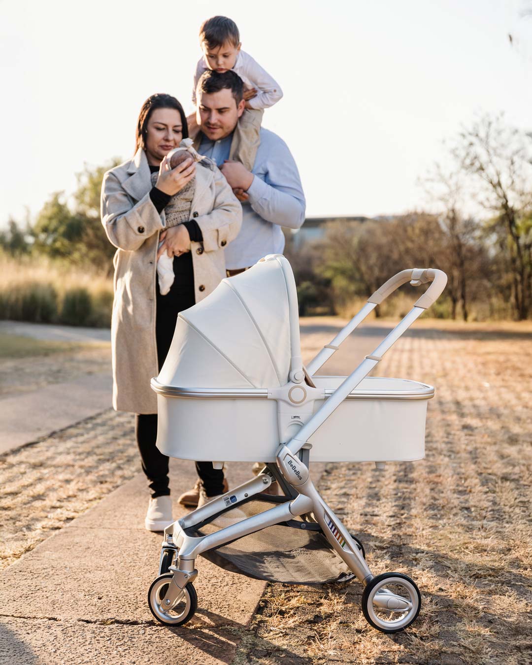 Family walking outdoors with BeBeBus Bassinet travel system, perfect for newborn strolls.