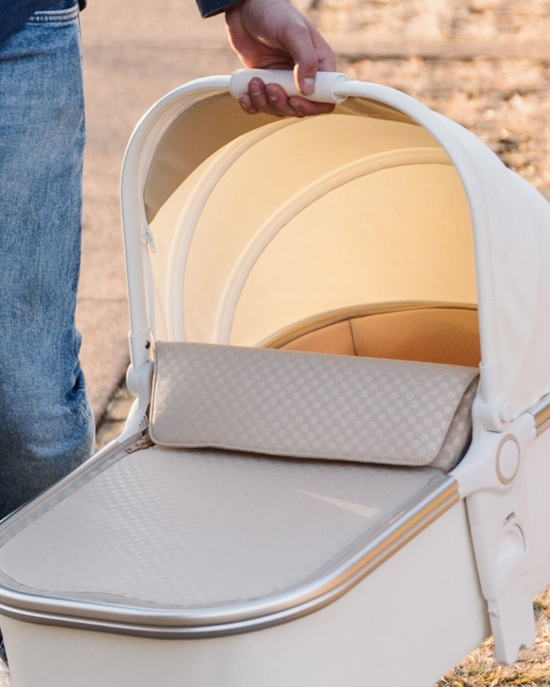 Hand holding the easy carry handle of the BeBeBus Bassinet with canopy and cover for newborns and infants.