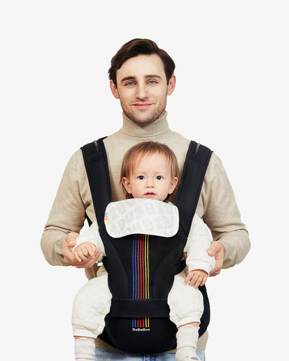 Man holding a baby in a black baby carrier with colorful stripes on a white background